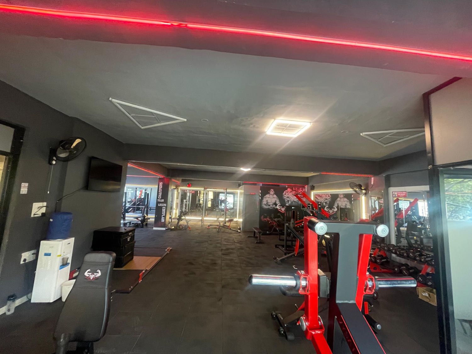 Inside BurnZone gym — dark training floor with red LED lighting and strength equipment